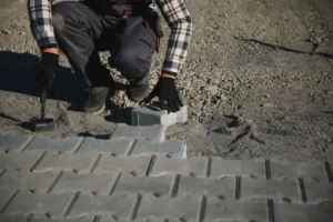 Un homme qui installe des revêtements de sol pour son parking extérieur