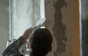 Un homme qui répare une fissure de maison