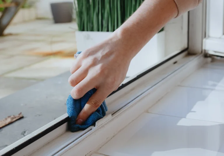 Une personne qui entretient rails baie vitrée coulissante