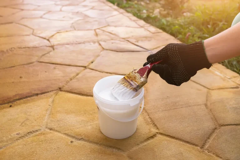 Une personne qui applique de l'hydrofuge pierre extérieure