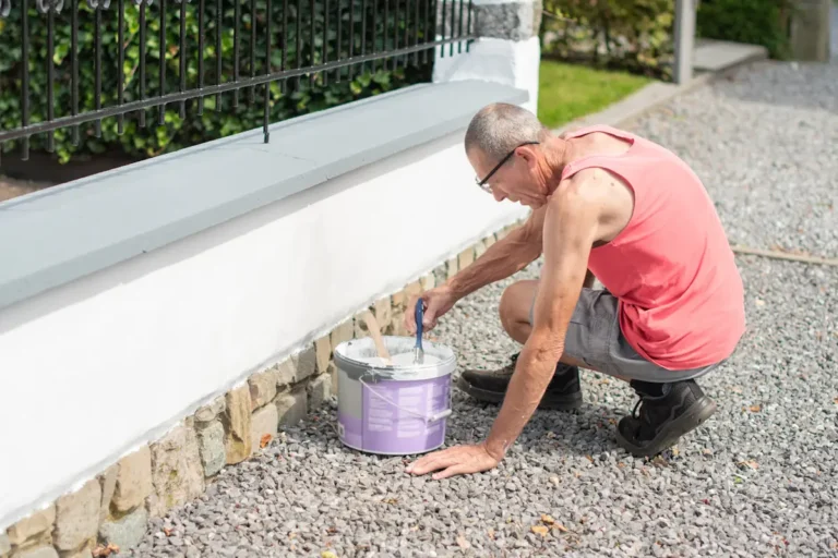 Un homme qui applique du joint pour pierre naturelle sur un mur extérieur