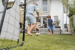 Une famille qui s'amuse sur un mini terrain de foot maison