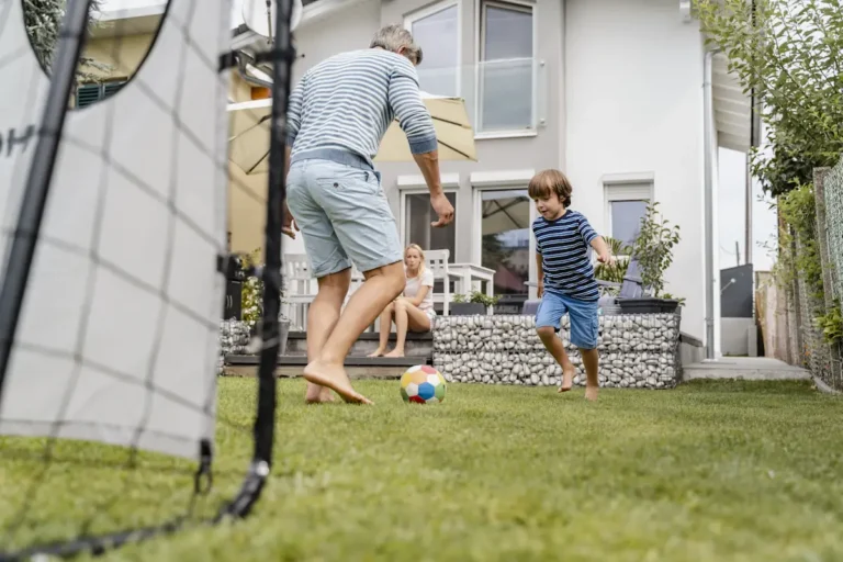 Une famille qui s'amuse sur un mini terrain de foot maison