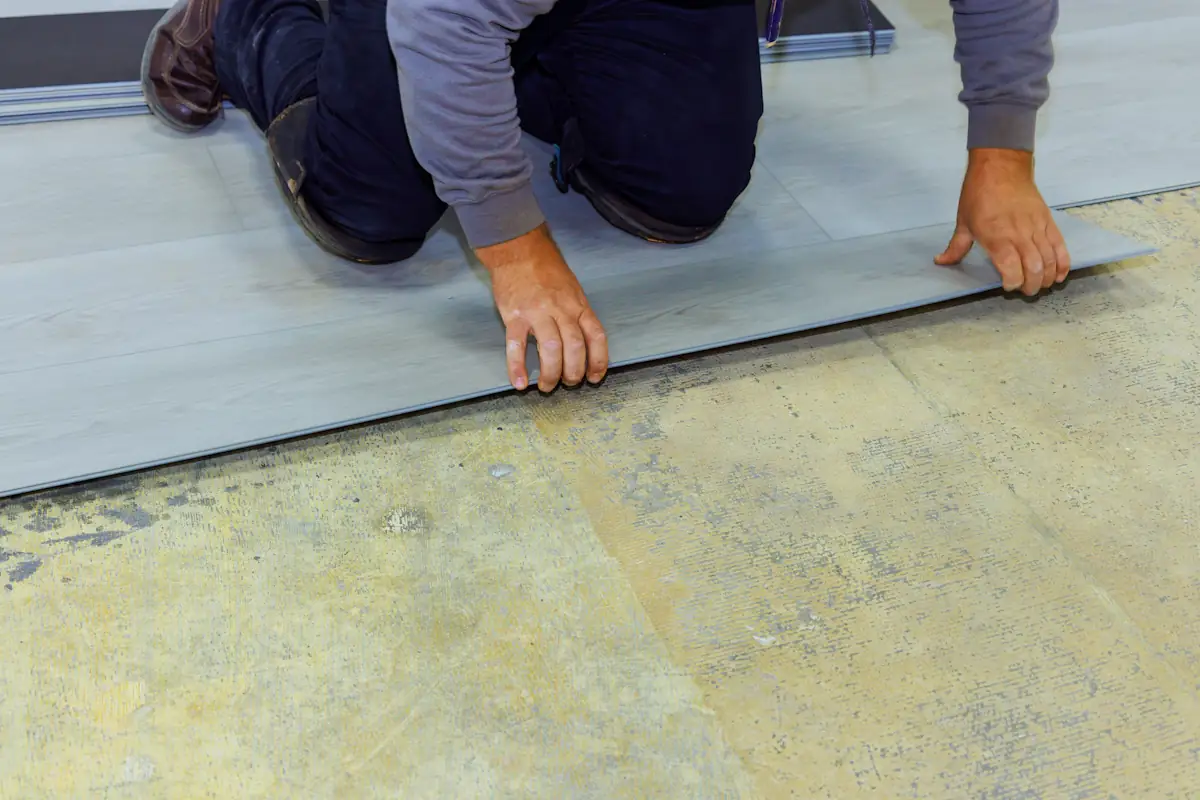 Un homme qui met un parquet flottant sur de la chape liquide