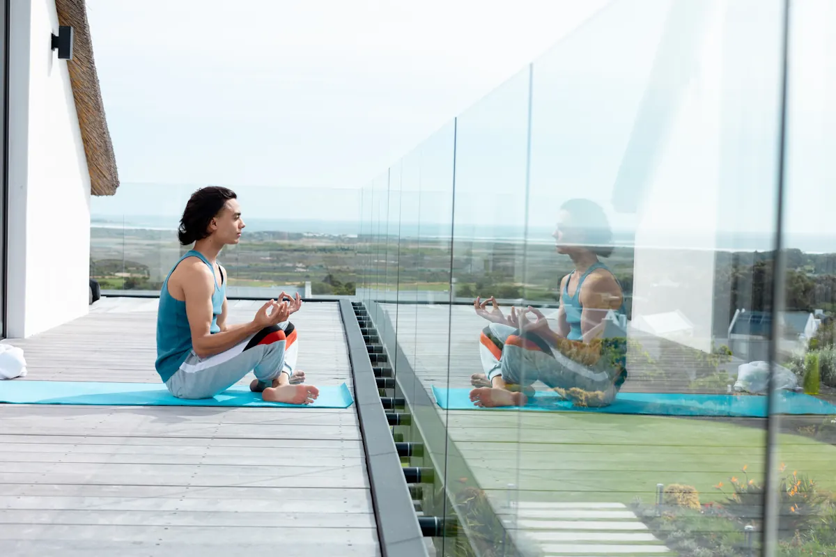 Une femme qui fait du yoga sur un balcon avec panneaux en verre trempé