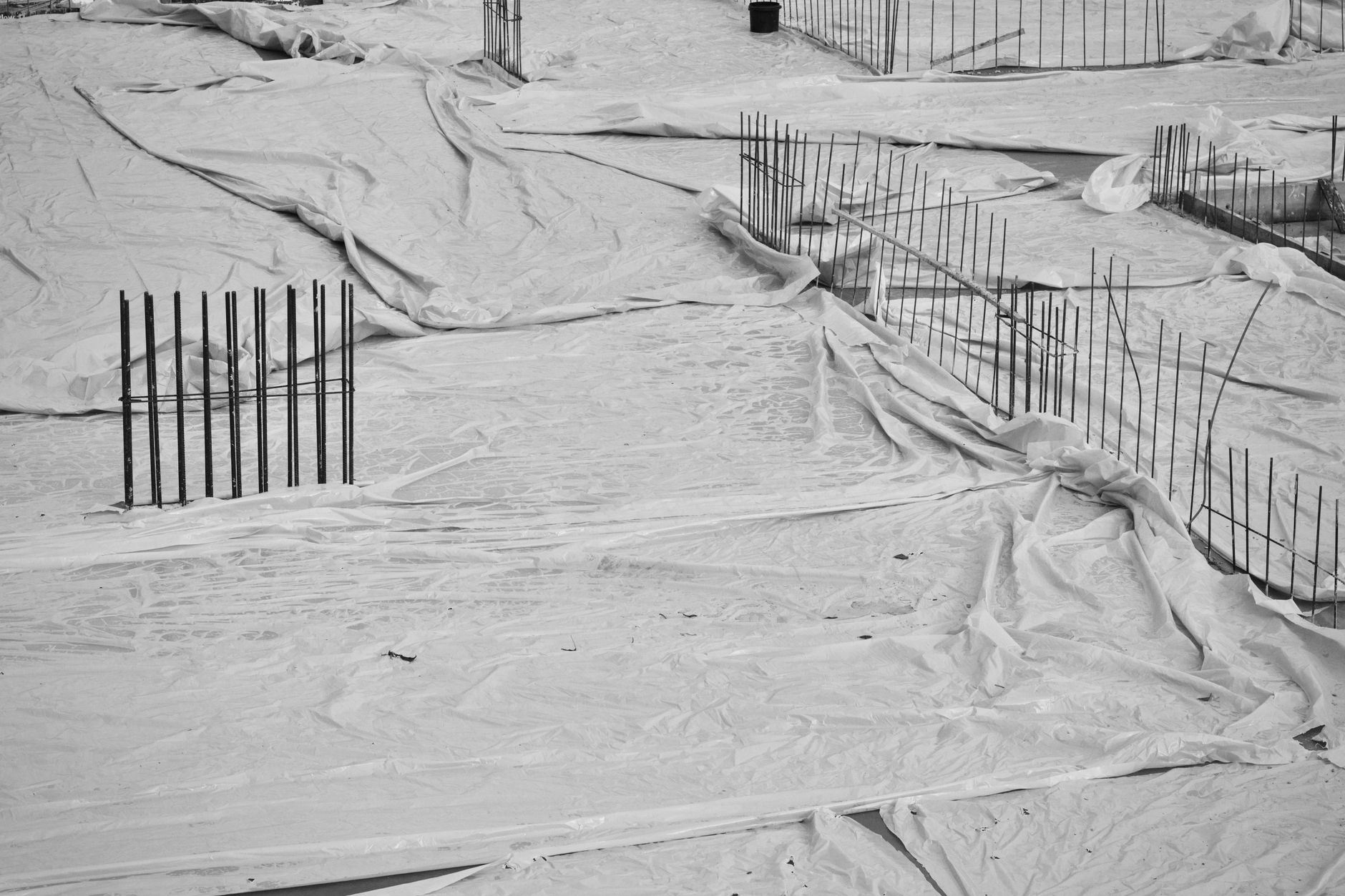 Film polyane déroulé sur hérisson de gravier avant coulage de dalle
