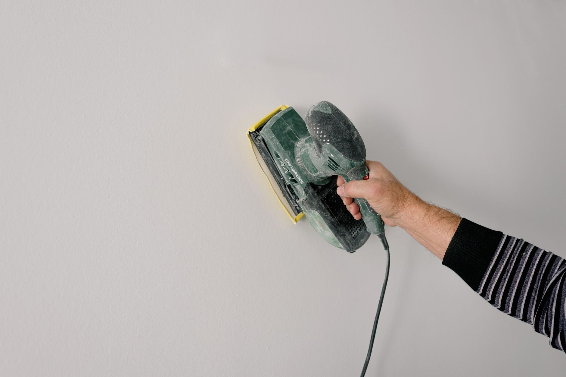 Ponçage d'une poutre en bois avant application de peinture
