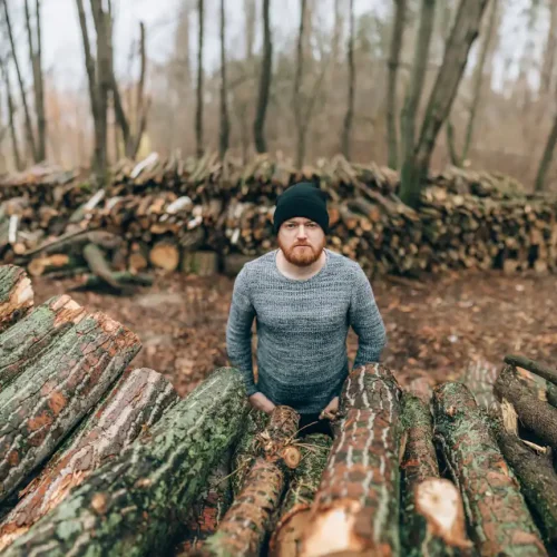 Un homme devant des bois de chauffage en 2 mètres
