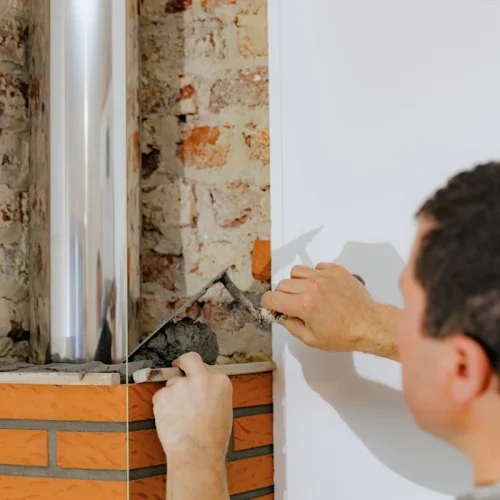 Un homme qui installe un conduit pour votre cheminée ou poêle