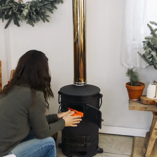 Une femme qui utilise un poêle à bois