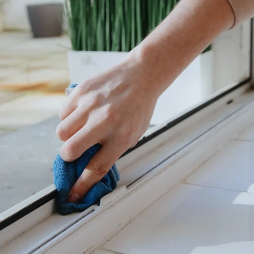 Une personne qui entretient rails baie vitrée coulissante