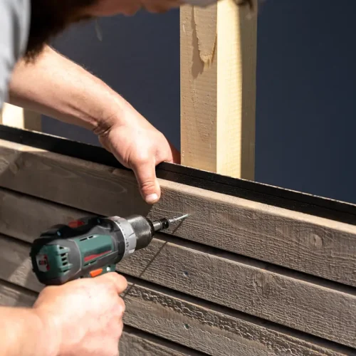 Une personne qui installe un garde-corps d'un balcon