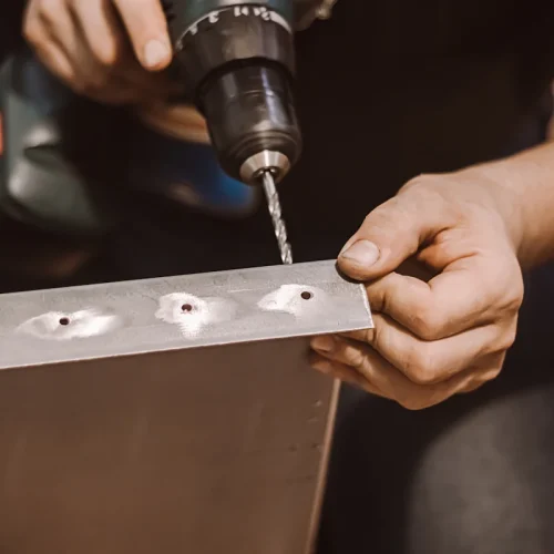 Un homme qui perce de l'inox